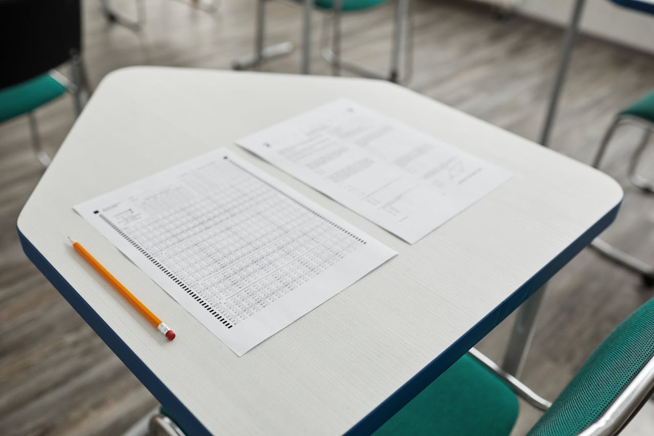 hero-img-02 A close-up image of an exam paper and pencil on a classroom desk, ready for a test.
